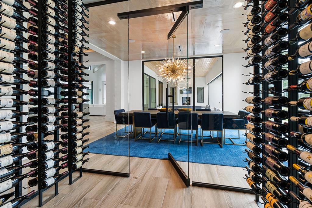 Extraordinary custom designed glass wine room offers plenty of display storage and is temperature controlled.