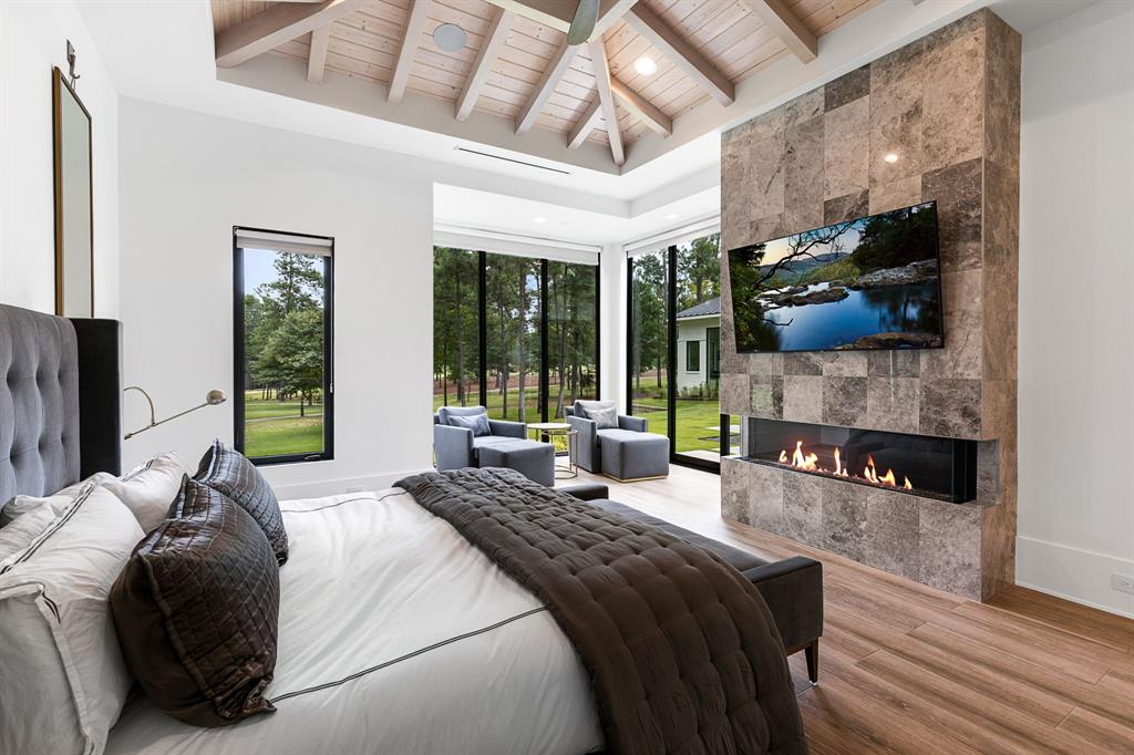 Seller's retreat showcases a linear electric fireplace with marble surround beneath a custom designed wood ceiling.