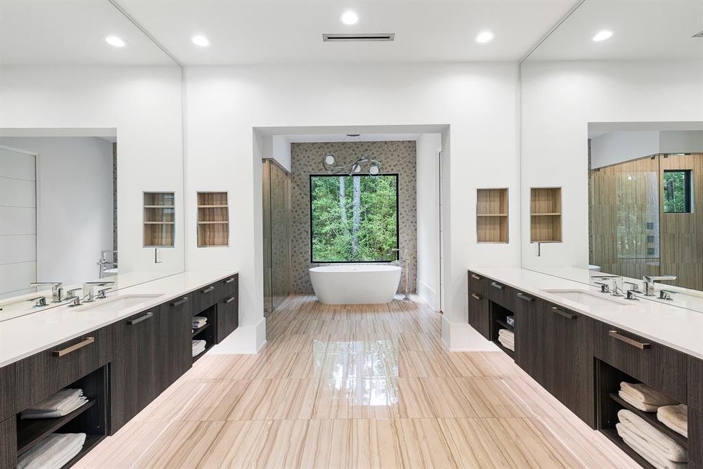 The primary bath highlights Madeval custom cabinetry and gorgeous Travertine flooring.