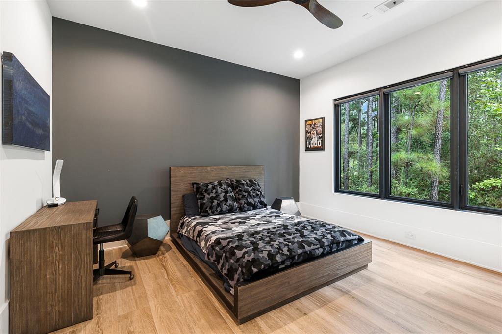 A roomy secondary bedroom offers casement windows highlighting a relaxing forested view.