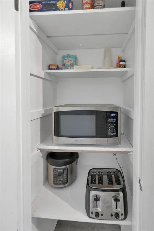 Pantry stocked with microwave, toaster and crockpot