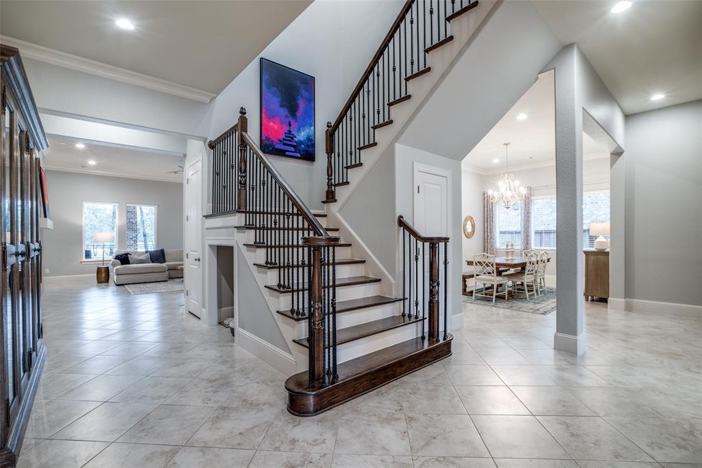 Wide entry foyer leads to grand staircase. Wood treads and risers.