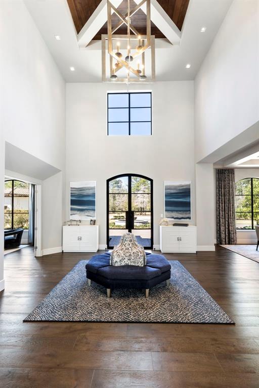 The foyer highlights a two story ceiling with custom beam accent and one of the homes many designer light features.