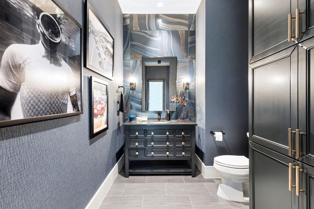 Game Room Powder Bath: is timeless with a polished designer backsplash of Agata Azzuro tile.