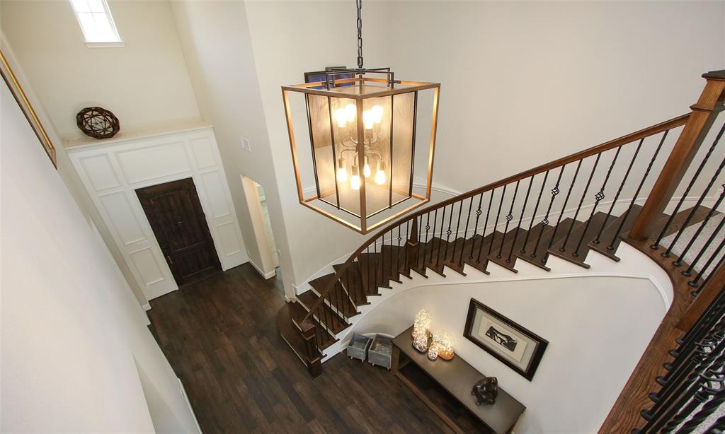 Elegant Light Fixture And Iron Staircase Adorn The Front Entry