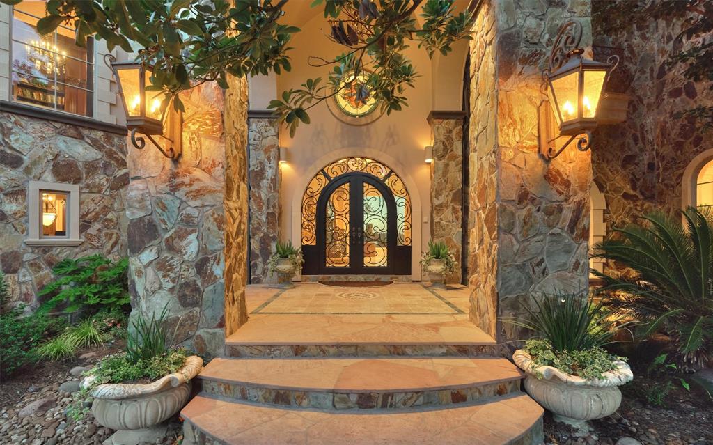 Absolute architectural perfection is what you find at every corner of this home beginning with the dramatic hand stone and stucco exterior features and grand wrought iron arched double doors.