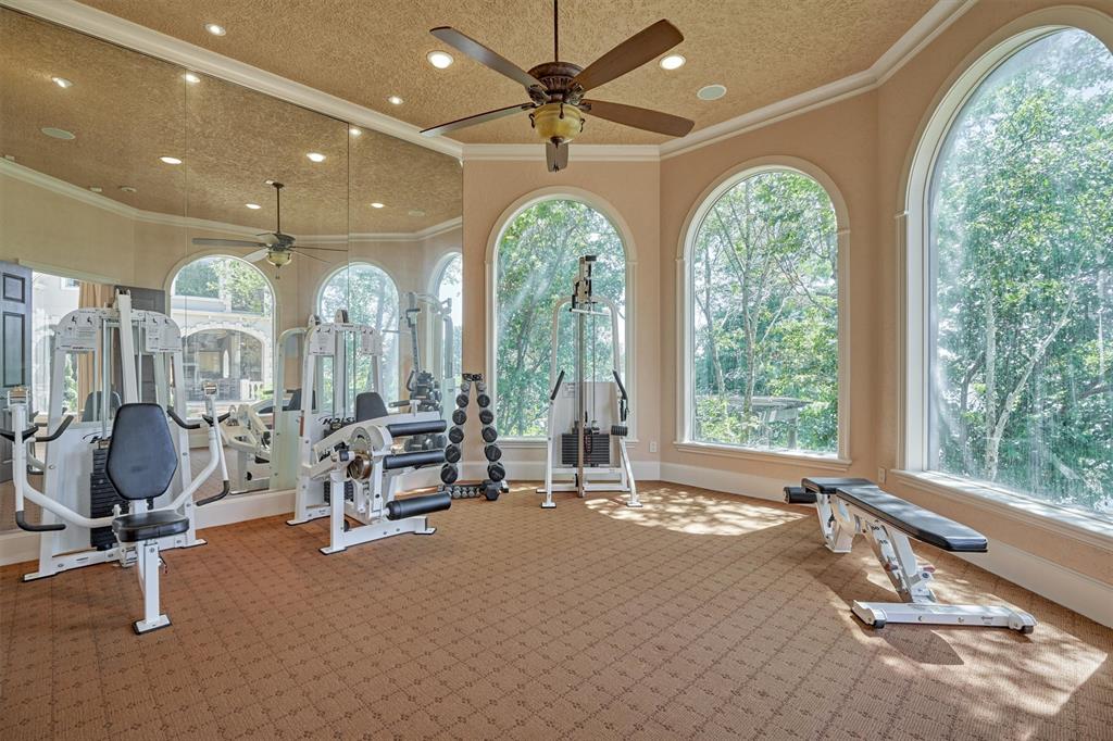 EXERCISE/FLEX ROOM - Located just off the primary bedroom and bath, this space is currently used as a home gym. One wall has "floor to ceiling" mirrors, ceiling fan, recessed lighting, carpet, base boards and multi-pane Anderson windows with incredible lake views.