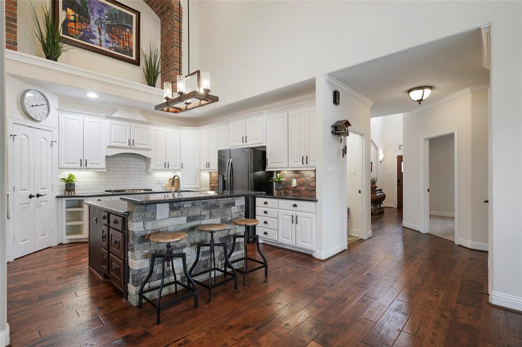 Gourmet island kitchen with brick arch. Granite counters, tons of storage, under cabinet lighting.